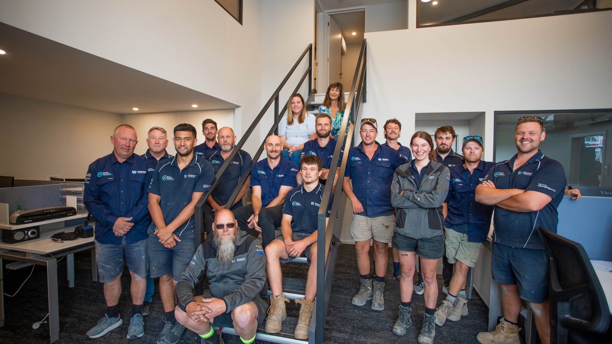 team of people sitting on stairs